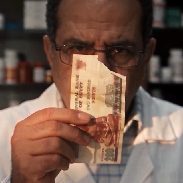 Pharmacist examining a damaged banknote in a pharmacy