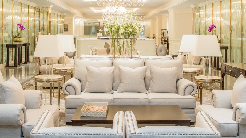 Luxurious hotel lobby with elegant beige sofas, white lamps, and a dark coffee table