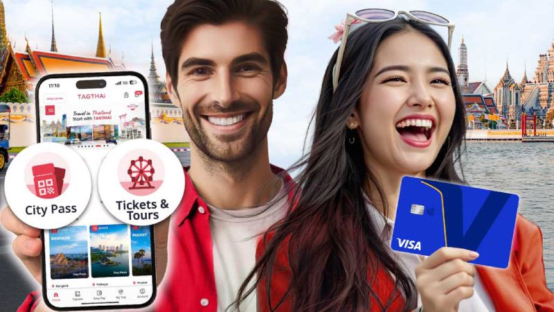 Smiling man and woman in bright clothing pose in front of Thai temple. Man holds phone displaying travel app, woman holding a credit card. 